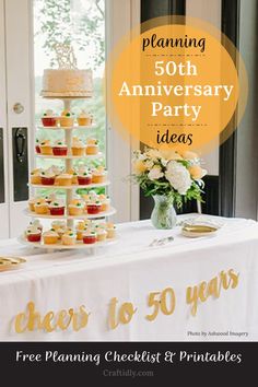 a table topped with lots of cupcakes next to a vase filled with flowers