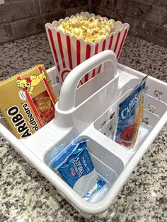 a tray filled with popcorn and snacks on top of a counter