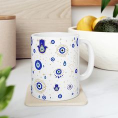 a blue and white coffee mug sitting on top of a counter next to some fruit