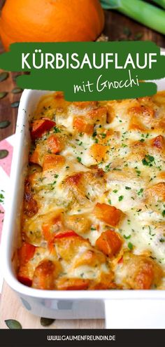 a casserole dish with cheese and vegetables in it on a table next to an orange