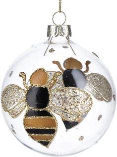 a glass ornament with a bee on it's side and gold glitters