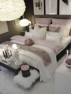 a white bed sitting in a bedroom on top of a fluffy rug next to two lamps