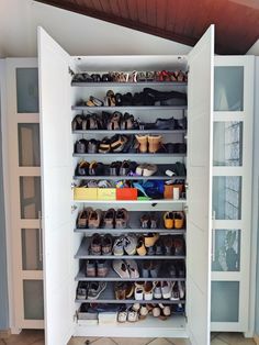 a closet filled with lots of shoes on top of shelves next to a wall mounted cabinet