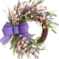 a wreath with purple ribbon and flowers