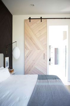 a bed sitting in a bedroom next to a wooden door on the side of a wall