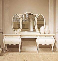 an ornate white dressing table with two mirrors