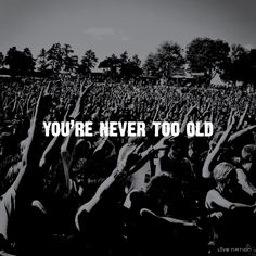 the words you're never too old are in front of a large group of people