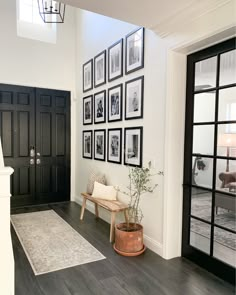 a living room filled with furniture and framed pictures on the wall above it's doorway