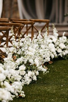 rows of chairs with white flowers lining the aisle