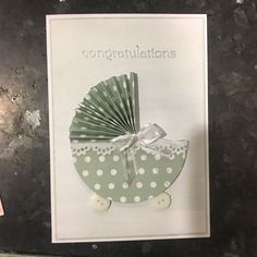 congratulations card with green and white polka dot buggy on the front, holding a fan