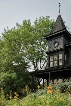 an old black house with a steeple and clock