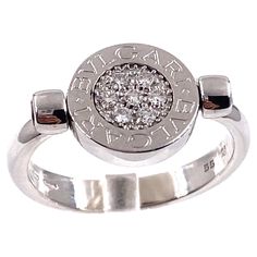 Bvlgari Pave Diamond & Black Onyx Flip Ring Style: Flip - Rotating Metal: 18kt White Gold Size: 7.5 Coin: 11 MM Stones: One side of Coin have 7 Round Brilliant Diamonds Pave Set 0.15 tcw - flip side has Black Onyx Color & Clarity: G color, VVS1 - VVS2 clarity Hallmark: Coin has " BVLGARI BVLGARI" on both sides " 55 MADE IN ITALY AU " Hallmarked on underside of ring Includes: Elegant Ring Box Retail: $3,750 Sku#11614TJF0123021 Flip Ring, Onyx Color, Onyx Colour, Elegant Ring, Ring Style, Ring Box, Cocktail Rings, Pave Diamonds, Black Onyx