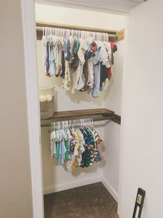 an open closet with clothes hanging on the rails