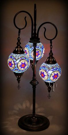 three colorful lights on a black stand against a dark background