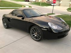 a black sports car parked in front of a stop sign