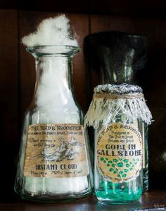 two old fashioned glass bottles sitting on top of a wooden table next to each other