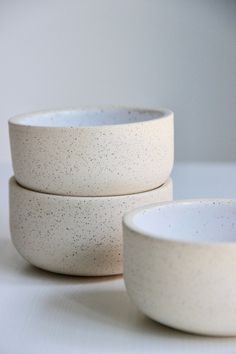 three white bowls sitting next to each other on a table