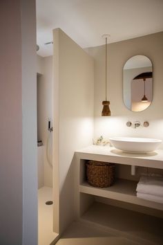 a bathroom with a sink, mirror and towel rack on the wall next to it