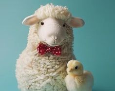 a stuffed sheep with a baby duck on a blue background