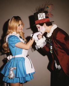 a man and woman dressed up as alice and the mad hatter, one in costume