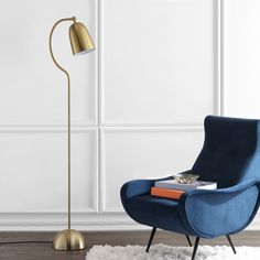 a living room with a blue chair and a gold lamp on the floor next to it