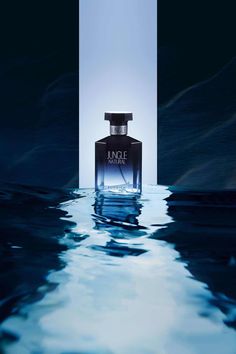 a bottle of perfume sitting in the middle of water