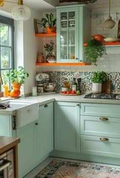 a kitchen filled with lots of green cupboards and counter top space next to a window