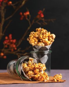 two glass containers filled with popcorn on top of a table