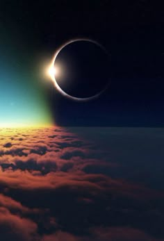 an eclipse in the sky with clouds below