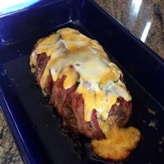 a steak covered in cheese and sauce on a blue plate