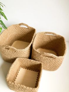 three woven baskets sitting on top of a white table