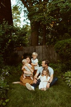 a family is sitting in the grass together