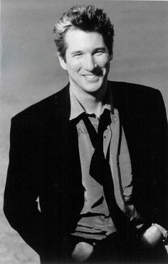 a black and white photo of a man in a suit with a smile on his face