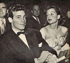 an old black and white photo of two people sitting next to each other at a formal event