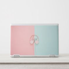 an open laptop computer sitting on top of a wooden table next to a white wall