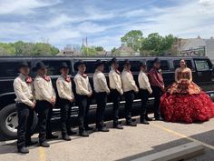 a group of people standing in front of a limo with dresses and cowboy hats on