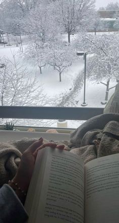 someone is reading a book in the snow