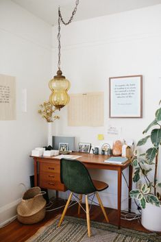 an image of a home office with plants and pictures on the wall, including a green chair