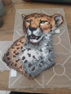 a cheetah made out of legos sitting on top of a wooden table