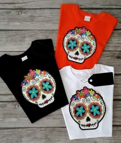 three t - shirts with colorful sugar skulls on them