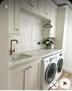 a washer and dryer in a white kitchen with herringbone backsplash