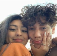 two young people posing for the camera with their hands on their cheeks and one holding her face