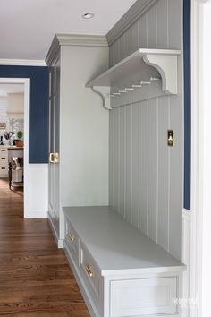 a kitchen with blue walls and white cupboards in the corner, along with wooden floors