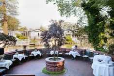 an outdoor dining area with tables and white tablecloths set up on the brick patio