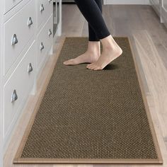 a woman standing on the kitchen floor with her feet up