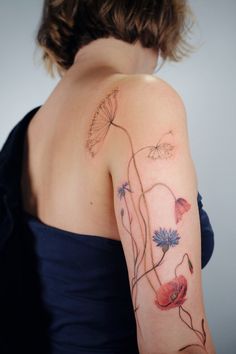 a woman's arm with flowers and butterflies on the back of her left arm