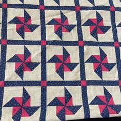 a blue and white quilt with red stars on it's sides, sitting on top of a table