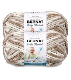 two balls of bernat baby blanket yarn in white and beige colors on a white background