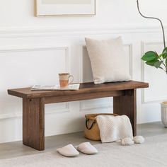 a wooden bench sitting next to a potted plant on top of a white rug