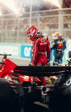 a man standing next to a red race car